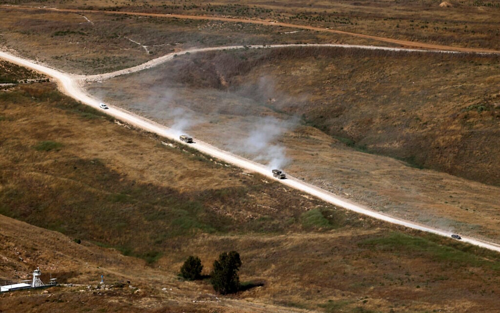 This picture taken from a position in the Upper Galilee region in northern Israel, shows Israeli military vehicles driving along a road in southern Lebanon on June 22, 2026 (Jalaa MAREY / AFP) /