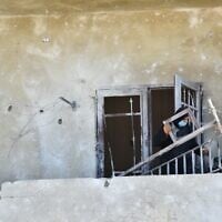 A Lebanese woman removes broken metal railing from her damaged house following Israeli military strikes, in the southern Lebanese village of Srifa on June 24, 2026. (Photo by Fadel ITANI / AFP) /