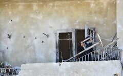 A Lebanese woman removes broken metal railing from her damaged house following Israeli military strikes, in the southern Lebanese village of Srifa on June 24, 2026. (Photo by Fadel ITANI / AFP) /