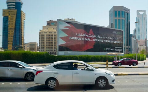 Cars drive past a billboard that reads, 'Bahrain is Safe... Because you are its People' in Manama on June 25, 2026 (Eric Lee / POOL / AFP)