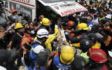 Rescuers load a person onto an ambulance after being pulled alive from the rubble of a collapsed building in Caraballeda, La Guaira state, Venezuela, on June 28, 2026, following back-to-back earthquakes. (Mauricio Valenzuela/AFP)