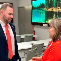 Then-US Senate candidate Jackson Lahmeyer, a Tulsa-area pastor, speaks to Edmond resident Winona Heltzel on March 15, 2022, at the H&H Shooting Sports gun range in Oklahoma City. (AP Photo by Sean Murphy_File)