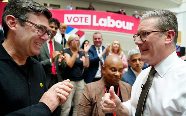 Keir Starmer, right, speaks to Greater Manchester Andy Burnham, June 13, 2024. (AP Photo/Jon Super)