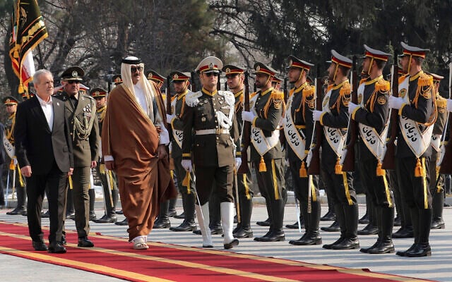 Qatar's Emir Sheikh Tamim bin Hamad Al-Thani, third left, reviews an honour guard as he is welcomed by Iran's President Masoud Pezeshkian, left, during his official welcoming ceremony at the Saadabad Palace in Tehran, Iran, February 19, 2025. (Iranian Presidency Office via AP)