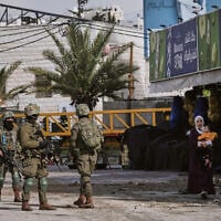 Illustrative: Israeli soldiers take up positions during an army raid in the West Bank city of Hebron on January 19, 2026. (AP Photo/Mahmoud Illean)