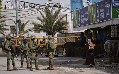 Illustrative: Israeli soldiers take up positions during an army raid in the West Bank city of Hebron on January 19, 2026. (AP Photo/Mahmoud Illean) Illustrative: Israeli soldiers take up positions during an army raid in the West Bank city of Hebron on January 19, 2026. (AP Photo/Mahmoud Illean)