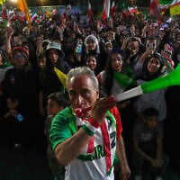 A man wearing a shirt bearing Iran's national soccer team logo blows a plastic trumpet during a pro-government gathering in support of Iran's World Cup team at Islamic Revolution Square in Tehran, Iran, Wednesday, May 13, 2026. (AP Photo/Vahid Salemi)