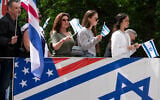 Parade participants wave flags at spectators during the Israel Day Parade, May 31, 2026, in New York. (AP/Emil T. Lippe)