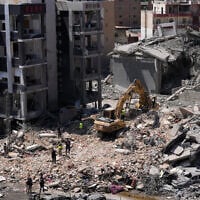Rescue workers use an excavator to search under the rubble of a building that was hit a day earlier in an Israeli airstrike in the southern port city of Tyre, Lebanon, June 2, 2026. (AP Photo/Mohammed Zaatari)