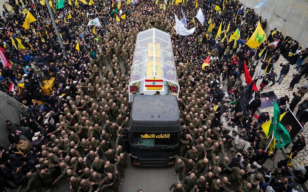 A trailer carrying the coffins containing the bodies of Hezbollah's former leader Hassan Nasrallah and his cousin and successor Hashem Safieddine drives through the crowd as it enters the Sports City Stadium during a funeral procession in Beirut, February 23, 2025. (Hassan Ammar/AP)