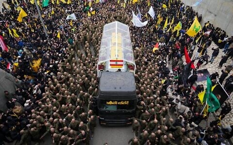 A trailer carrying the coffins containing the bodies of Hezbollah's former leader Hassan Nasrallah and his cousin and successor Hashem Safieddine drives through the crowd as it enters the Sports City Stadium during a funeral procession in Beirut, February 23, 2025. (Hassan Ammar/AP)