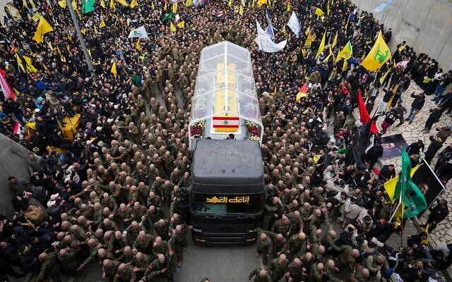 A trailer carrying the coffins containing the bodies of Hezbollah's former leader Hassan Nasrallah and his cousin and successor Hashem Safieddine drives through the crowd as it enters the Sports City Stadium during a funeral procession in Beirut, February 23, 2025. (Hassan Ammar/AP)