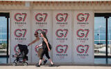 People walk past a G7 banner in Evian-les-Bains, eastern France, on May 28 , 2026, where the G7 summit is set to take place June 15–17. (AP Photo/Baz Ratner)