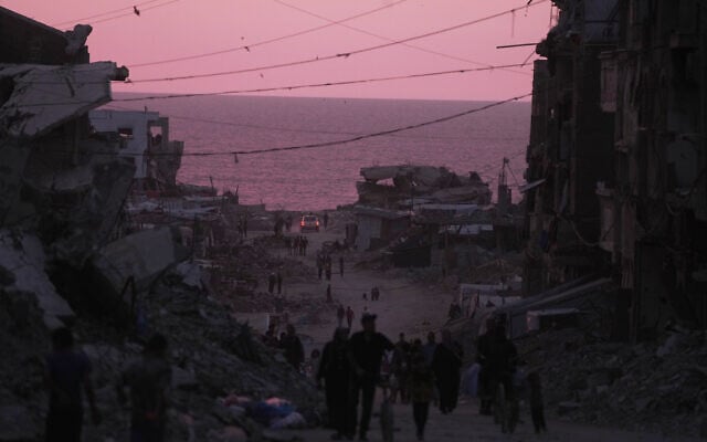 Palestinians walk between destroyed buildings in Gaza City, Wednesday, June 3, 2026. (AP Photo/Jehad Alshrafi)