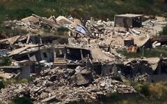 An Israeli flag hangs on a destroyed building in southern Lebanon as seen from northern Israel, on June 4, 2026. (AP Photo/Ariel Schalit)