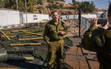 Avichay Adraee, the Israeli military’s Arabic language spokesman, stands beside weapons the army says were seized from Hezbollah in Lebanon, at an army base in northern Israel, December 23, 2024. (AP Photo/Ohad Zwigenberg)