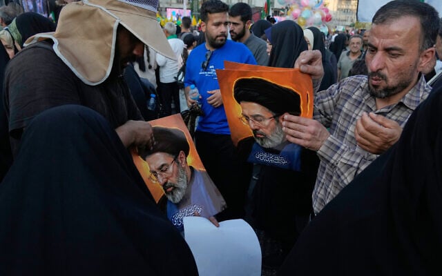 A man hands out posters of Iranian Supreme Leader Ayatollah Mojtaba Khamenei during a street festival celebrating the Muslim Shiite holiday of Eid al-Ghadir in Tehran, Iran, on June 4, 2026. (AP Photo/Vahid Salemi)