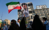 A woman holds up an Iranian flag in front of a banner showing a portrait of Supreme Leader Ayatollah Mojtaba Khamenei during a street festival celebrating the Muslim Shiite holiday of Eid al-Ghadir in Tehran, Iran, June 4, 2026. (AP/Vahid Salemi)