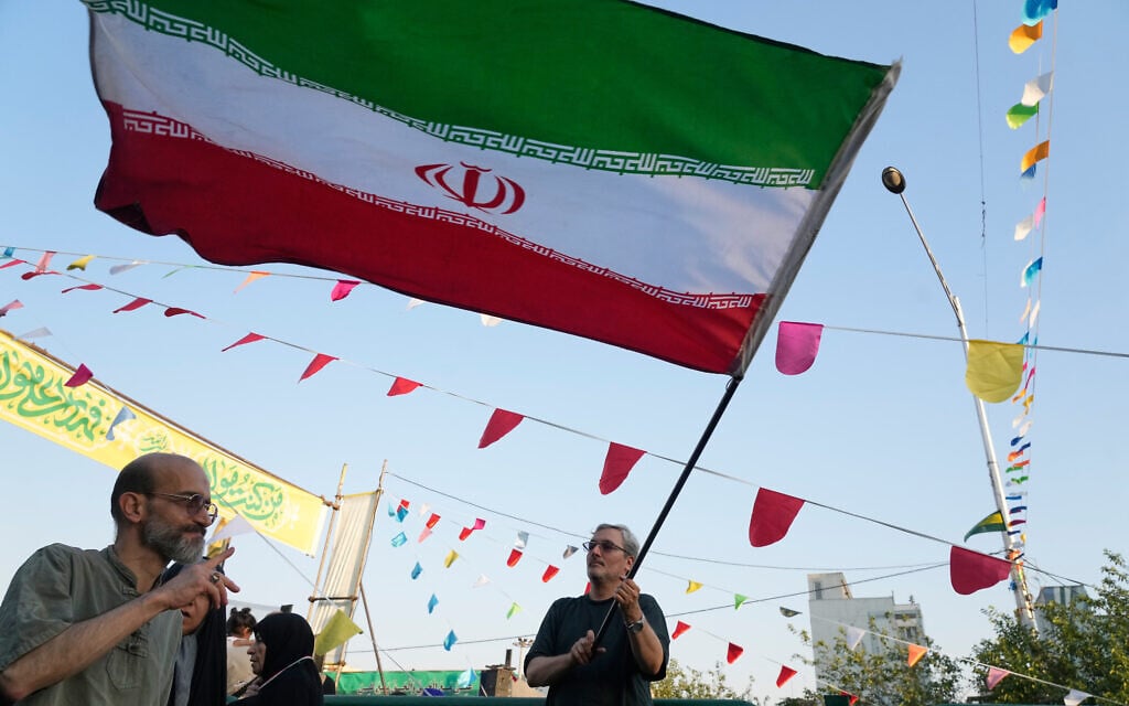 A man waves an Iranian flag during a street festival celebrating the Muslim Shiite holiday of Eid al-Ghadir, the anniversary Prophet Muhammad naming his successor, Ali, who is revered as the first Shiite Imam, in Tehran, Iran, June 4, 2026. (AP Photo/Vahid Salemi)