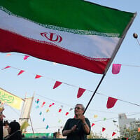 A man waves an Iranian flag during a street festival celebrating the Muslim Shiite holiday of Eid al-Ghadir, the anniversary Prophet Muhammad naming his successor, Ali, who is revered as the first Shiite Imam, in Tehran, Iran, June 4, 2026. (AP Photo/Vahid Salemi)