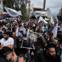 FILE - Sunni Muslims hold a portrait of imprisoned Sunni cleric Ahmad al-Assir, center right, during a protest against the clause in a proposed amnesty law that would exclude some prisoners, including the cleric, from being eligible for amnesty, after Friday prayers in Beirut, Lebanon, May 22, 2026. (AP Photo/Bilal Hussein, File)
