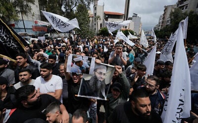FILE - Sunni Muslims hold a portrait of imprisoned Sunni cleric Ahmad al-Assir, center right, during a protest against the clause in a proposed amnesty law that would exclude some prisoners, including the cleric, from being eligible for amnesty, after Friday prayers in Beirut, Lebanon, May 22, 2026. (AP Photo/Bilal Hussein, File)