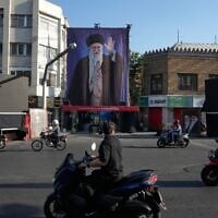 Motorbikes drive near the residence where the late Iranian Supreme Leader Ayatollah Ali Khamenei, shown on a banner, was killed in US and Israeli strikes on February 28, in Tehran, Iran, Saturday, June 6, 2026. (AP Photo/Vahid Salemi)