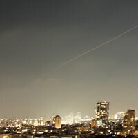 A projectile streaks through the sky over central Israel during an Iranian missile attack, June 7, 2026. (AP Photo/Ohad Zwigenberg)
