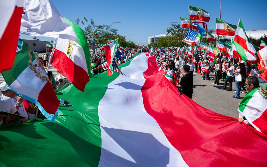 People carry a giant pre-revolutionary Iranian flag during a protest in reaction to FIFA's ban on the flag inside World Cup stadiums, June 7, 2026, in Inglewood, California (AP Photo/Benjamin Hanson)