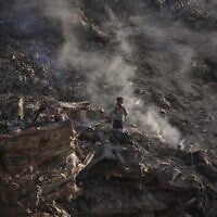 A child walks amid rubble and landfill in Gaza City, June 8, 2026. (AP Photo/Jehad Alshrafi)