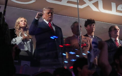 US President Donald Trump gestures during the National Anthem as he attends an NBA Finals playoff basketball game between the New York Knicks and the San Antonio Spurs at Madison Square Garden in New York, June 8, 2026, with Kai Trump, left, Knicks owner James Dolan and Interior Secretary Doug Burgum, right. (Mark Schiefelbein/AP)