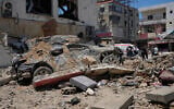 A car lies amidst debris following an Israeli airstrike in the southern port city of Tyre, Friday, June 12, 2026. (AP Photo/Mohammed Zaatari)