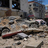 A car lies amidst debris following an Israeli airstrike in the southern port city of Tyre, Friday, June 12, 2026. (AP Photo/Mohammed Zaatari)