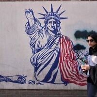A woman walks past an anti-American mural on the wall of the former US Embassy, now a museum, in Tehran, Iran, June 12, 2026. (AP Photo/Vahid Salemi)
