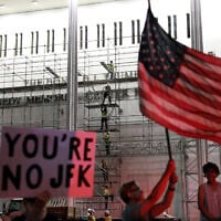 People wait for US President Donald Trump's name to be removed from the John F. Kennedy Center for the Performing Arts in Washington, Friday, June 12, 2026. (AP Photo/Rahmat Gul)