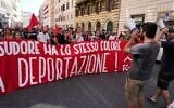 People hold a banner in Italian reading "Skin and sweat have the same color, no deportation' during a march in Rome, June 13, 2026, to protest Italy's security and migration package, including a migrant "repatriation bonus" scheme criticized by opposition parties and legal groups as unconstitutional and ethically problematic. (AP Photo/Gregorio Borgia)
