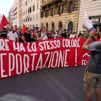 People hold a banner in Italian reading "Skin and sweat have the same color, no deportation' during a march in Rome, June 13, 2026, to protest Italy's security and migration package, including a migrant "repatriation bonus" scheme criticized by opposition parties and legal groups as unconstitutional and ethically problematic. (AP Photo/Gregorio Borgia)