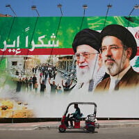 A man rides a scooter past a giant billboard that shows the former Iranian leader Ali Khamenei, center, and his son, Supreme Leader Ayatollah Mojtaba Khamenei, with Arabic writing that reads: "Thank you Iran," in Dahiyeh, Beirut's southern suburbs, Lebanon, June 15, 2026. (AP Photo/Hussein Malla)