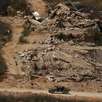 A Israeli military vehicle moves past destroyed buildings in southern Lebanon as seen from northern Israel, June 15, 2026. (AP/Leo Correa)
