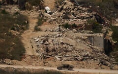 A Israeli military vehicle moves past destroyed buildings in southern Lebanon as seen from northern Israel, June 15, 2026. (AP/Leo Correa)