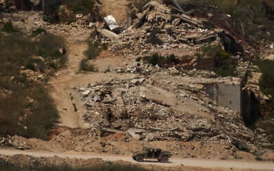 A Israeli military vehicle moves past destroyed buildings in southern Lebanon as seen from northern Israel, June 15, 2026. (AP/Leo Correa)