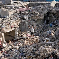 A man who returned to his village following the announcement of an initial ceasefire agreement between the United States and Iran, flashes a victory sign as he stands on the rubble of his destroyed house in Nabatiyeh town, southern Lebanon, June 16, 2026. (Hussein Malla/AP)