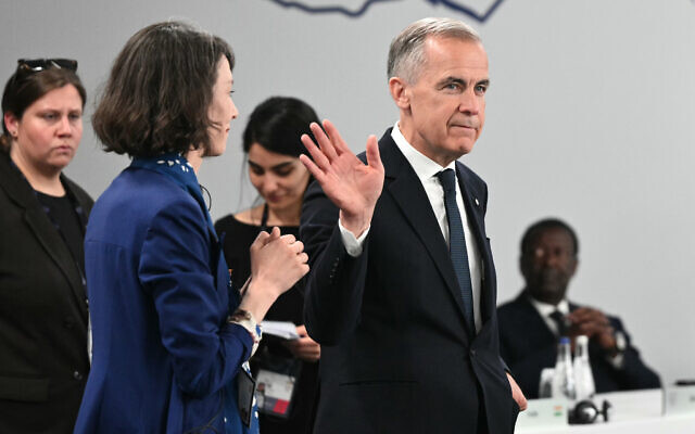 Canada's Prime Minister Mark Carney, right, gestures as he arrives,  ahead of a working session at the G7 summit, in Evian-les-Bains, France, June 17, 2026. (Mandel Ngan/Pool Photo via AP)