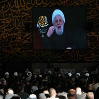 Hezbollah leader Sheikh Naim Qassem, is seen on a screen during a sermon marking the first day of Ashoura, at the grave of late Hezbollah leader Sayyed Hassan Nasrallah, left, in Beirut, Lebanon, June 17, 2026. (AP Photo/ Hussein Malla)