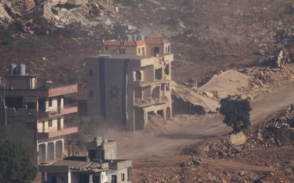 An Israeli flag covers a part of a damaged building in southern Lebanon seen from northern Israel, June 18, 2026. (AP Photo/Ariel Schalit)