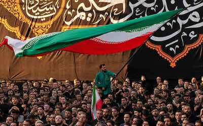 A man waves an Iranian flag as people beat their chests during a religious mourning ceremony in Tehran, Iran, on June 18, 2026. (AP Photo/Vahid Salemi) A man waves an Iranian flag as people beat their chests during a religious mourning ceremony in Tehran, Iran, on June 18, 2026. (AP Photo/Vahid Salemi)