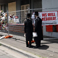 People gather outside the Adass Israel Synagogue, December 9, 2024, after a firebombing in Melbourne, Australia. (Con Chronis/AAP Image via AP)