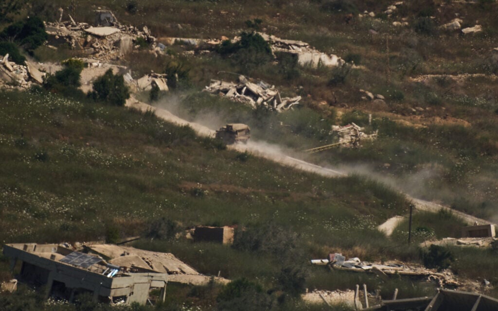 An IDF military vehicle moves past destroyed buildings in southern Lebanon as seen from northern Israel, June 19, 2026. (AP Photo/Leo Correa)