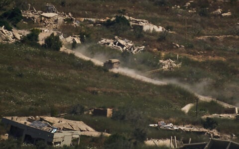An IDF military vehicle moves past destroyed buildings in southern Lebanon as seen from northern Israel, June 19, 2026. (AP Photo/Leo Correa)