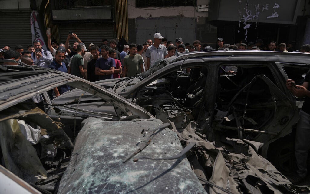 Palestinians inspect damaged vehicles following an Israeli airstrike in Gaza City, June 22, 2026. (AP Photo/Jehad Alshrafi)